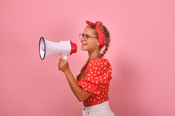 年轻开朗的白人少女拿着扩音器站在演播室里图片下载