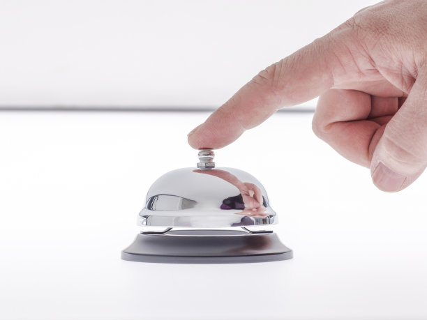 一个男人的手摇着接待铃图片下载