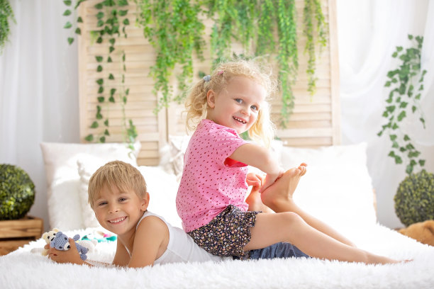 可爱幼儿在床上挠脚，欢笑，儿童恶作剧，幸福图片下载