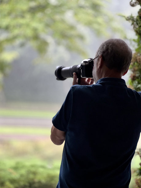 老人在雨中拍照图片下载
