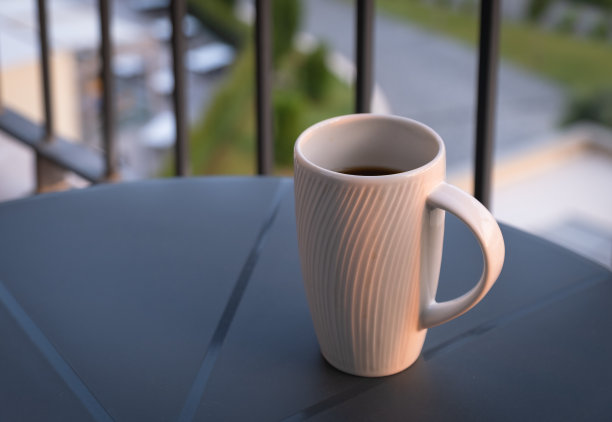 日出时阳台桌上的咖啡杯。图片下载