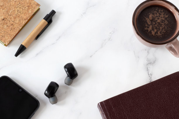 圣经，一杯咖啡，无线耳机，智能手机，笔记本电脑，白色的钢笔，俯视图图片下载