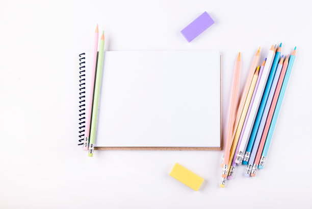 白色的桌子上有很多彩色铅笔和速写本图片下载
