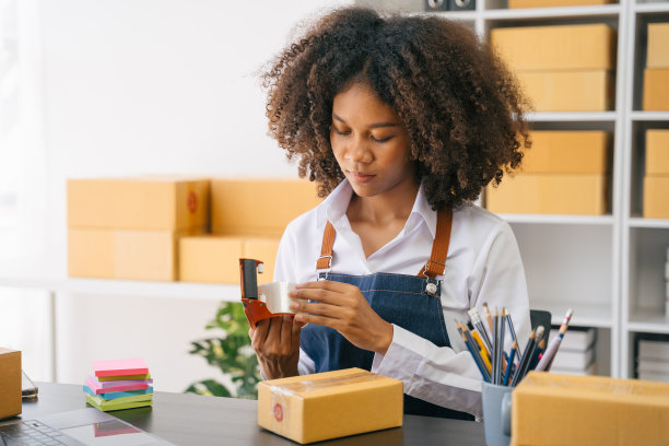 创业小企业主在家工作，用胶带密封纸箱，网上购物业务，电子商务和交付给客户的概念。图片下载