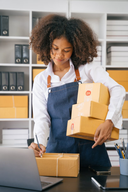 网上销售产品的概念。企业家或自由职业者检查客户的订单，该女子在网站和社交媒体上经营电子商务业务。图片下载