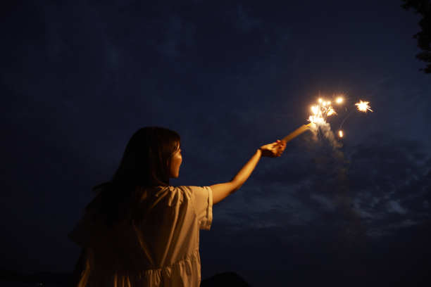 一位30多岁的日本妇女在夏天的海边手持烟花图片下载