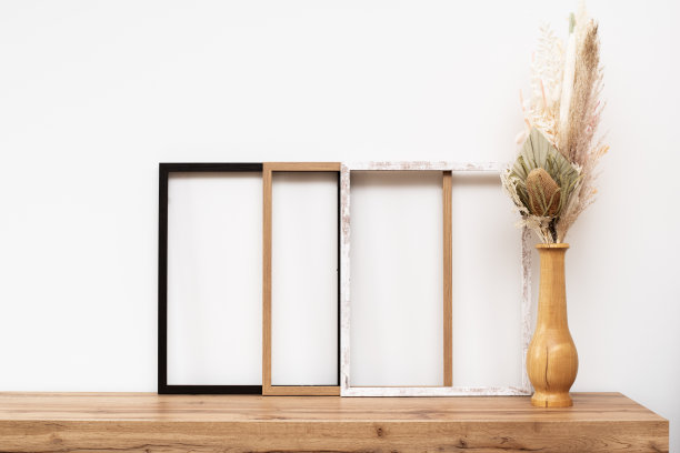 装饰靠墙的木制相框，用装饰花装饰木制抽屉柜。图片下载