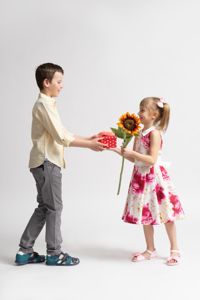 大男孩表示祝贺，并送给小女孩一份节日礼物。图片下载