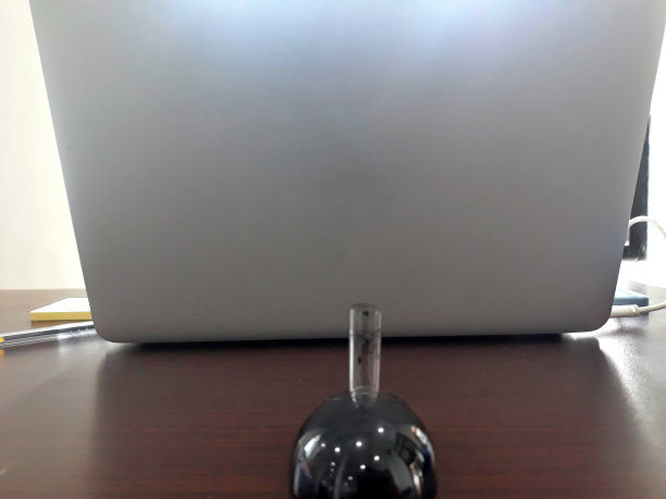 笔架放在前台的笔记本电脑上。在工作区域系好笔图片下载