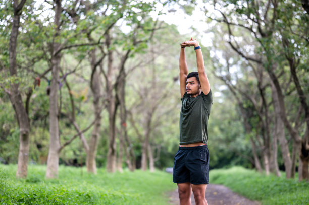 一个年轻的运动男子开始他的日常锻炼伸展运动的镜头图片下载