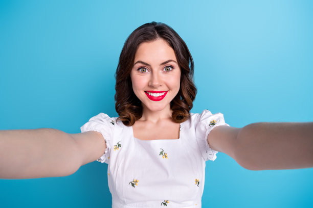 照片的酷迷人的女孩穿着白色的顶部视频日志录制视频孤立的蓝色背景图片下载