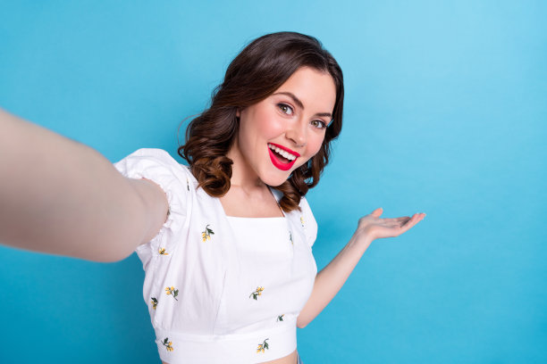 漂亮可爱的积极女孩的照片，在蓝色背景上展示了空白的空间方式图片下载