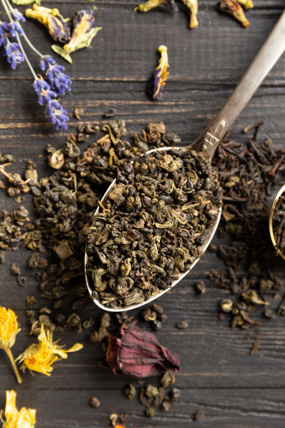 干绿茶和红茶，花茶在黑暗的背景上俯视图特写。图片下载