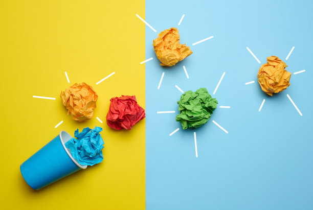 灵感与新想法的概念，寻找创造性的解决方案，在蓝黄背景上揉成球状的纸张图片下载