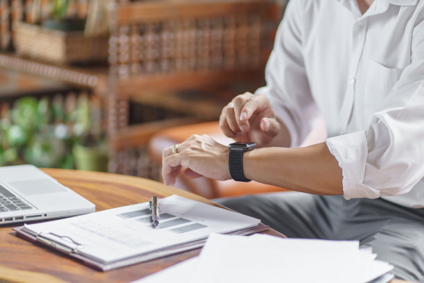 商务人士看atÂ智能手表在办公室在线连接小工具技术图片下载
