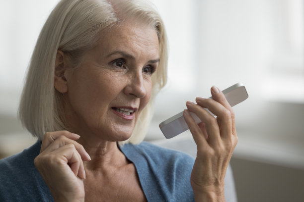 积极的年长女士用手机说话图片下载
