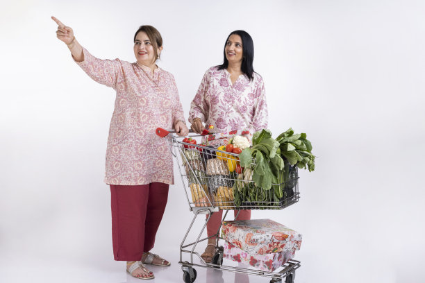 两个女人一起购物，推着购物车，孤立在白色的背景上，图片下载