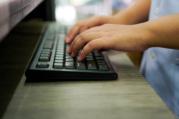 图片显示了一个人正在使用药物输送系统的电脑键盘输入信息。图片下载