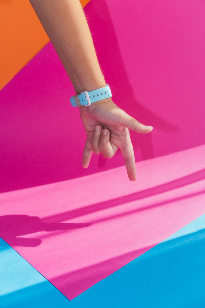 手在明亮的彩色背景上显示出犄角手势标志，风格极简图片下载