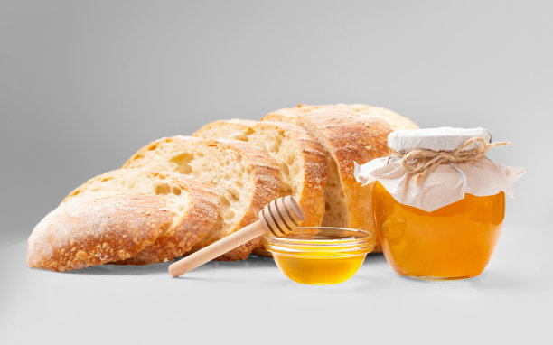 白色背景上的切片面包、蜂蜜罐和小勺图片下载