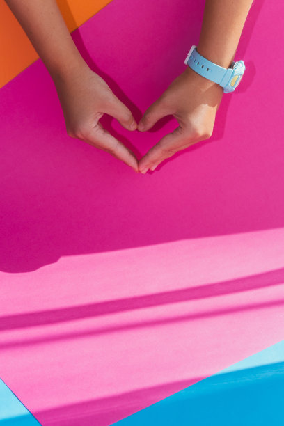 这只手在极简主义的彩色背景上显示了心形手势图片下载