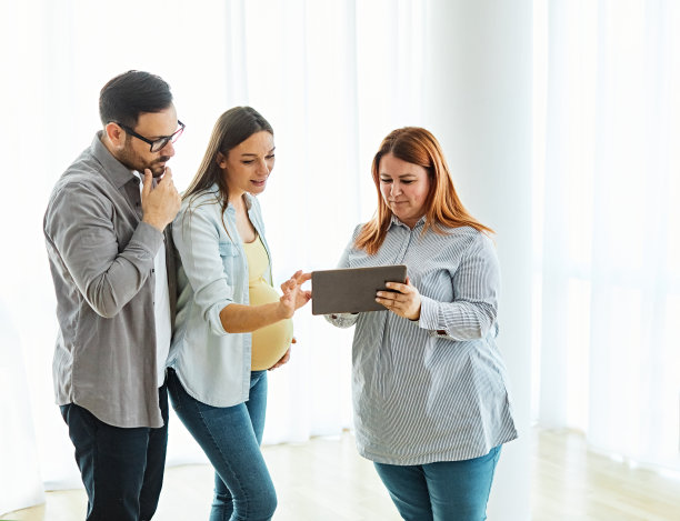 夫妇房产经纪人房屋房地产业务购买投资公寓协议交易客户买家新贷款怀孕母亲会议协议签署合同孕妇腹部平板电脑显示电脑图片下载