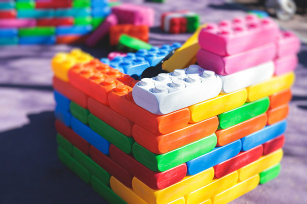 孩子们在幼儿园日托中心的操场上玩着五颜六色的大积木，孩子们在玩着各种塑料积木图片下载