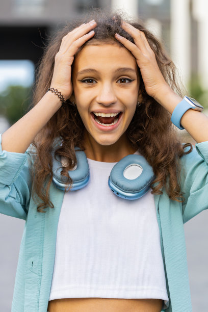 十几岁的女孩看着镜头，被突如其来的胜利消息震惊了，哇在城市街道上图片下载