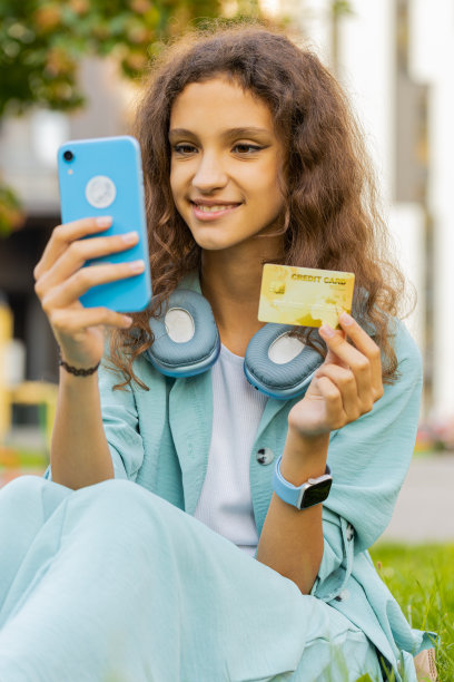 青春期前的女孩使用信用卡智能手机转账、网购图片下载
