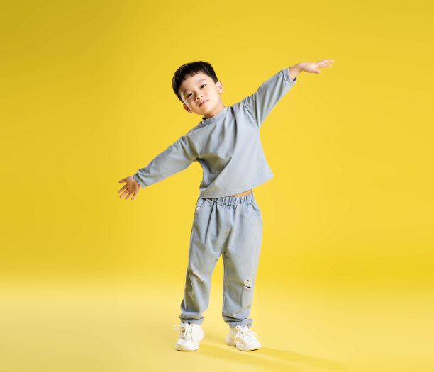 男孩在黄色背景上摆姿势的全身照片图片下载