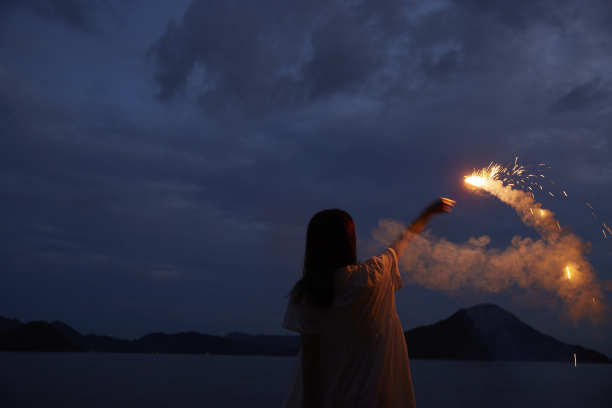 一位30多岁的日本妇女在夏天的海边手持烟花图片下载