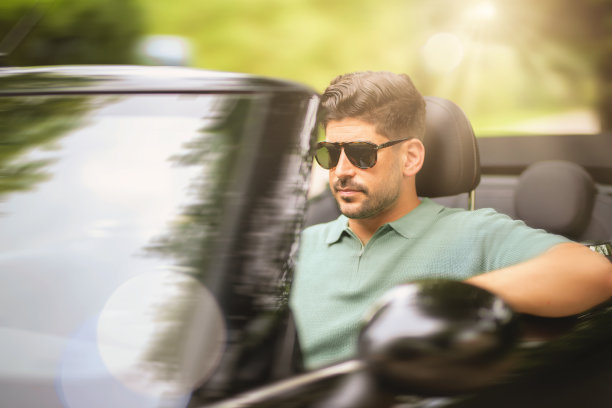 英俊的中年男子开着一辆高速敞篷车图片下载