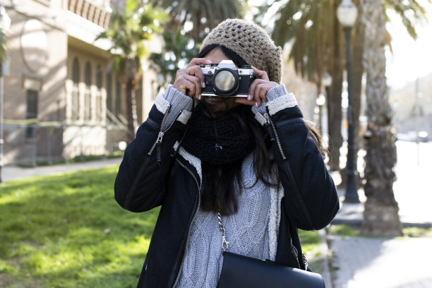 微笑的女旅行者拿着相机在城市度假——放松，旅游的概念图片下载