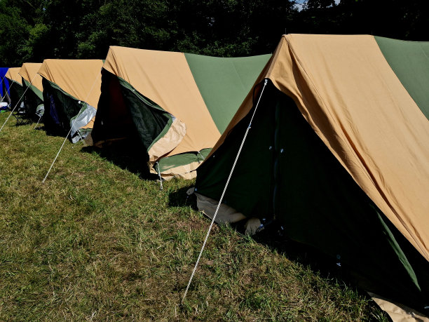 几个帐篷，一个有运动设备的帐篷，经理和女厨师的帐篷。在草地上长时间露营用的帆布帐篷图片下载
