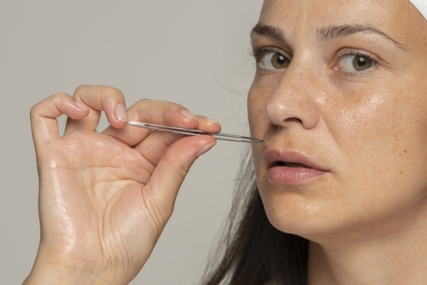 一位年轻女子用一撮头发拔她的胡子图片下载