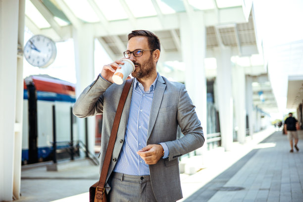 商务人士正在等火车，喝着咖啡。图片下载
