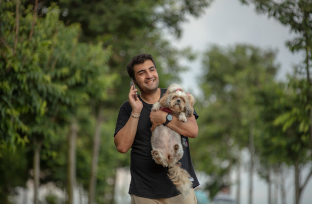 年轻男人在公园遛狗图片下载