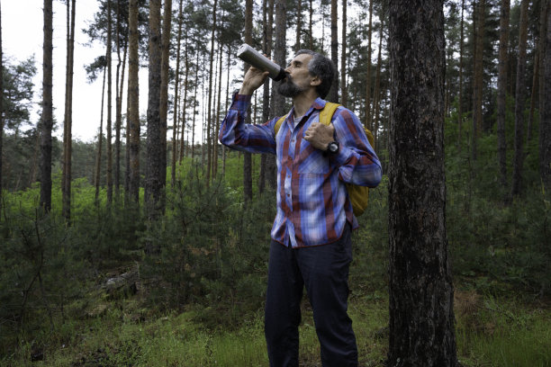 一个人在春天的树林里徒步旅行。图片下载