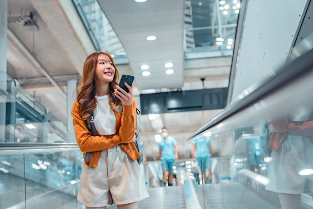 快乐迷人的亚洲女性旅行者与背包在现代机场航站楼，复制空间，旅游旅行的概念图片下载