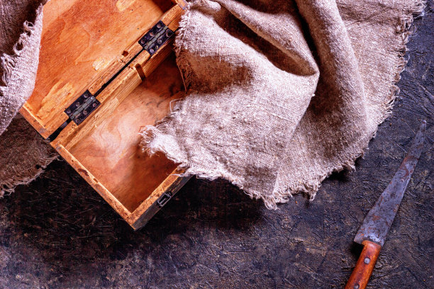 老式的屠刀和旧的木制橱柜在石头厨房表面图片下载