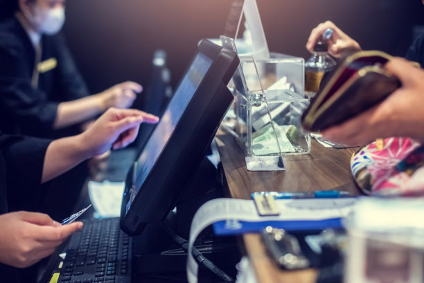 有选择地盯着POS机的边缘，模糊的收银员在餐厅或咖啡厅柜台服务中接收顾客的订单。图片下载