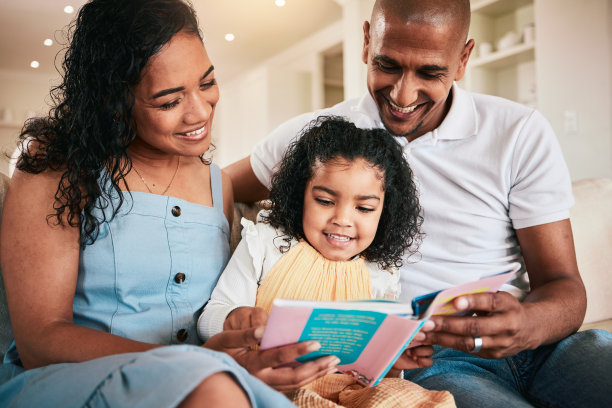 阖家欢乐，和孩子一起读故事书、卡通漫画书，和妈妈、爸爸或父母在家里亲密无间。爱，讲故事或青少年孩子听童话进行家庭教育学习图片下载