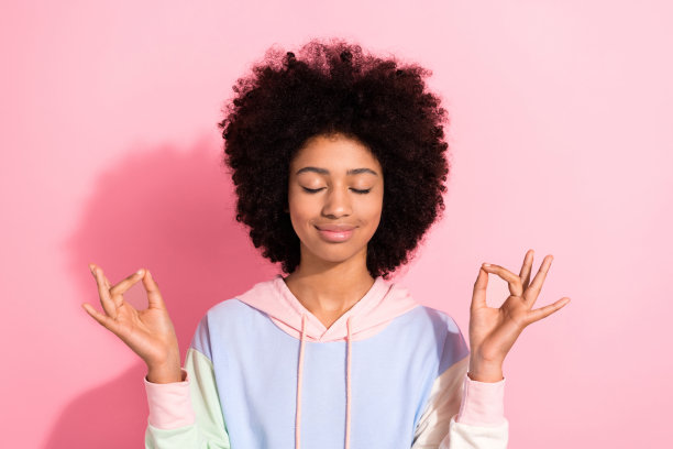 可爱的梦幻小孩的照片穿着运动衫闭着眼睛练习瑜伽孤立的粉红色背景图片下载