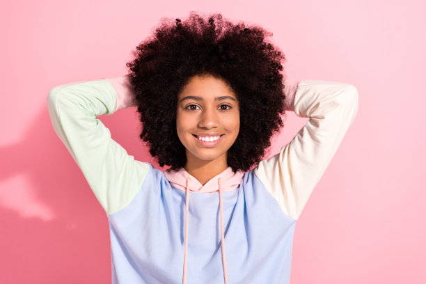 照片的可爱的漂亮的小孩穿着连帽衫微笑的手臂背后的头孤立的粉红色背景图片下载