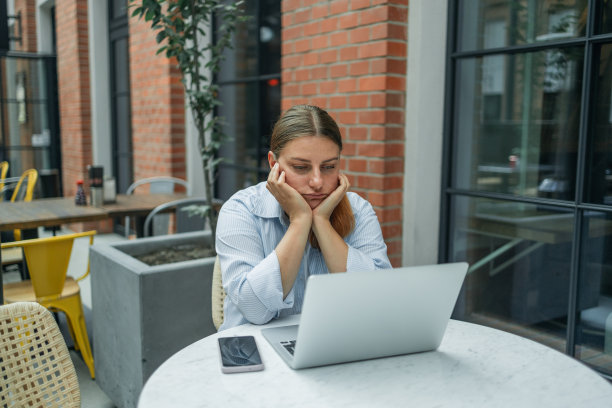 随意的商务女性认真对待笔记本电脑，高加索女性在工作场所或咖啡馆工作时感到压力和疲惫。图片下载