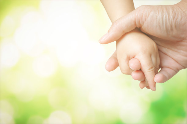 一起走路时，孩子的手握住父亲的手指，给予支持和保护。图片下载