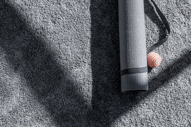 灰色地毯上的瑜伽垫。秋天在家进行体育活动图片下载