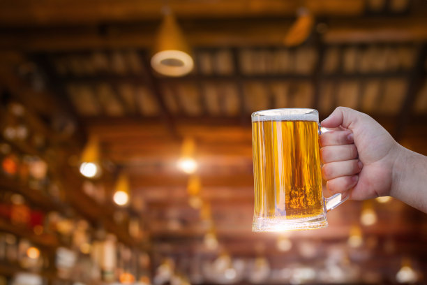 手里拿着一杯啤酒庆祝节日。图片下载