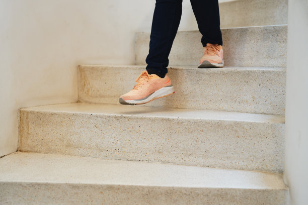 在楼下。近距离观察走下楼的女人的腿。图片下载