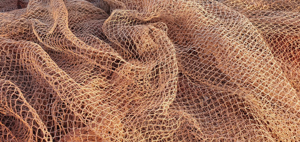 在海里捕鱼用的渔网。船上的渔网。渔网的质地。图片下载